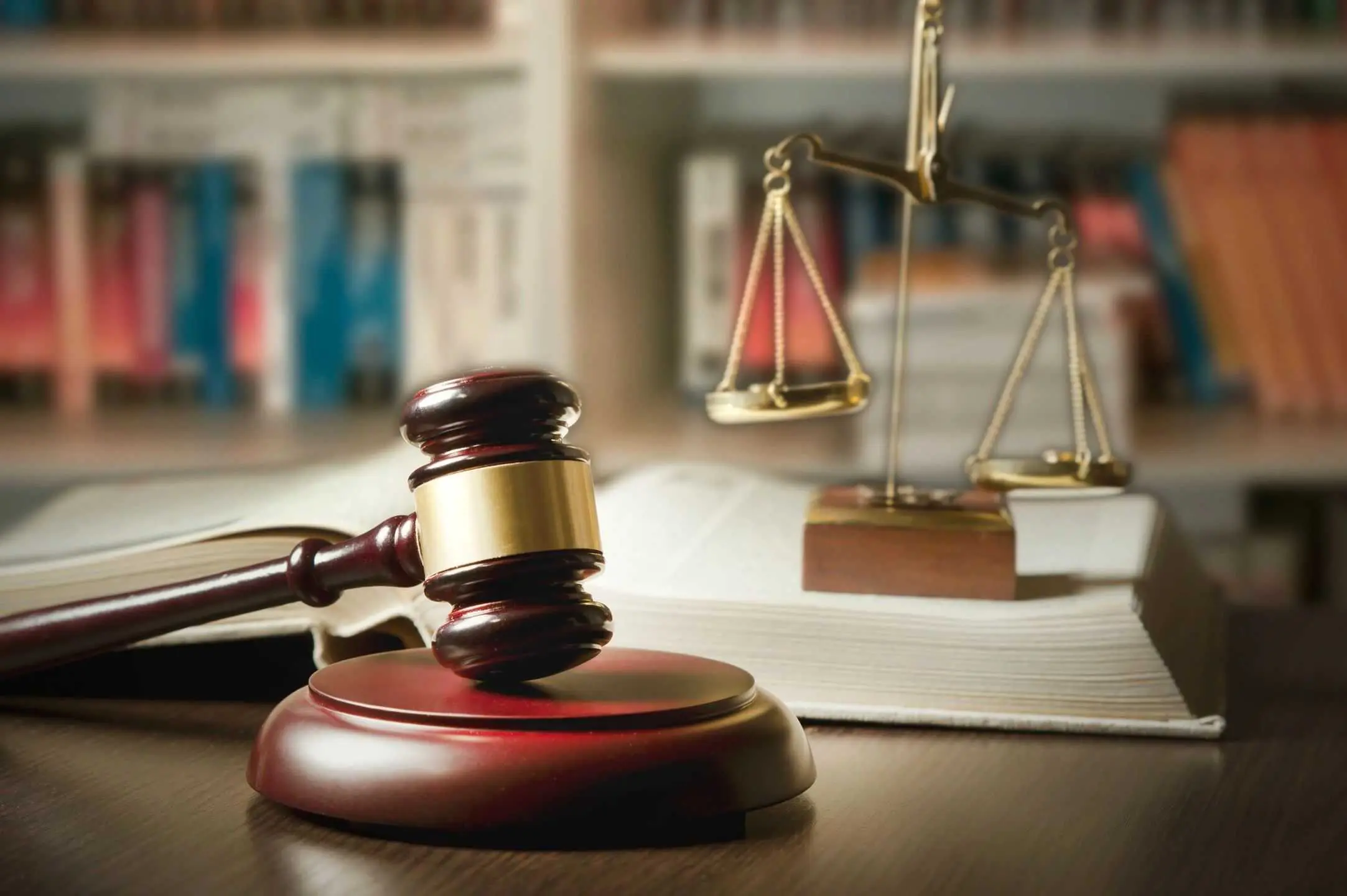 A judge 's gavel and scale of justice on a table.